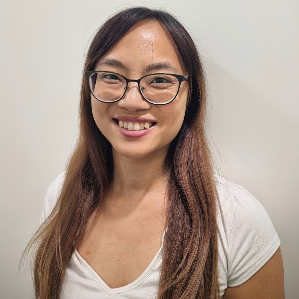 A smiling Asian woman named Serena Lee, wearing glasses and a white t-shirt, stands against a plain, light-colored background.