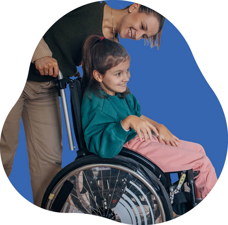 Photo of a girl in a wheelchair smiling as she is assisted by her caregiver