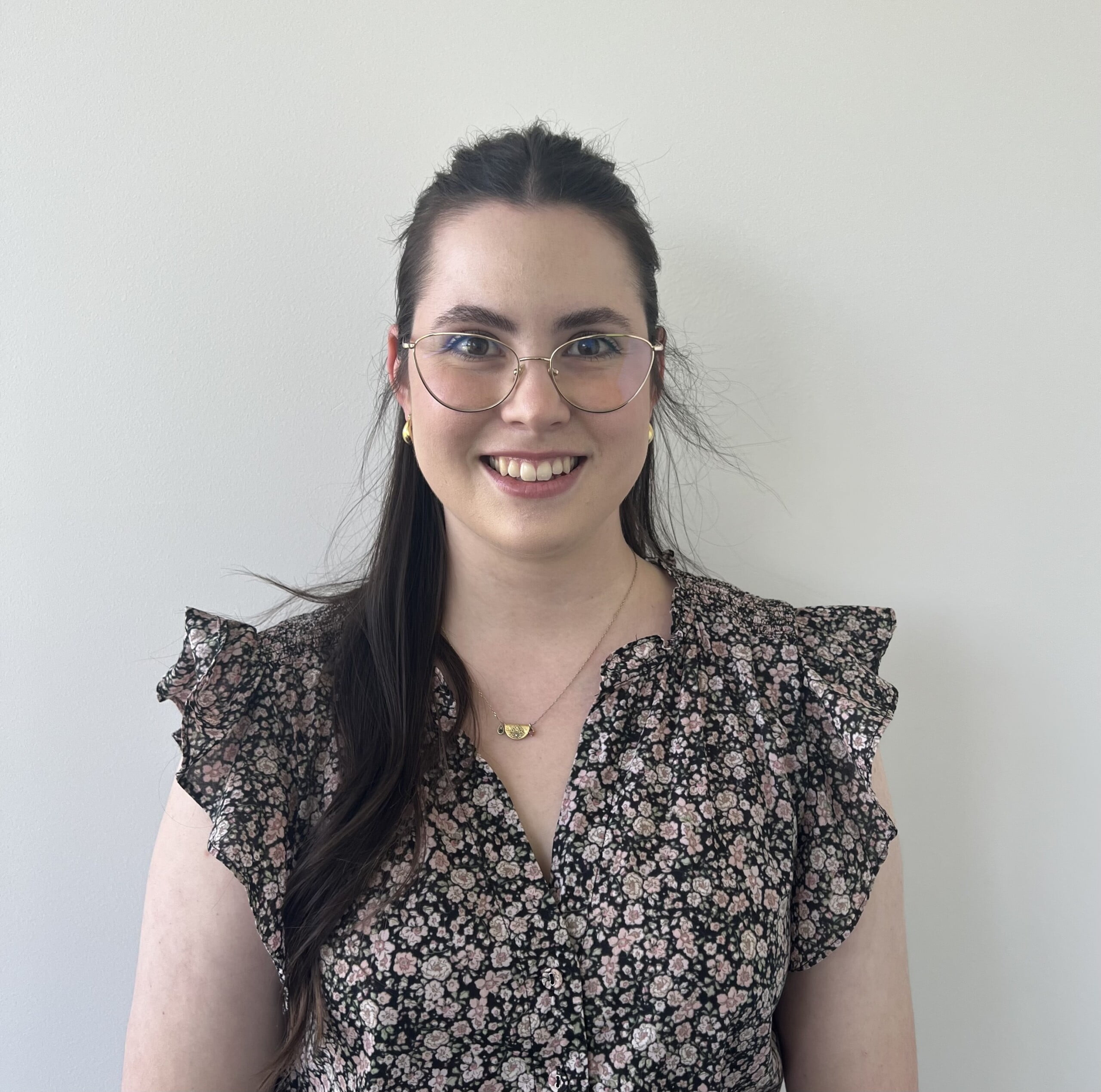 Emma Jaroslawski, a woman wearing glasses and a floral top.